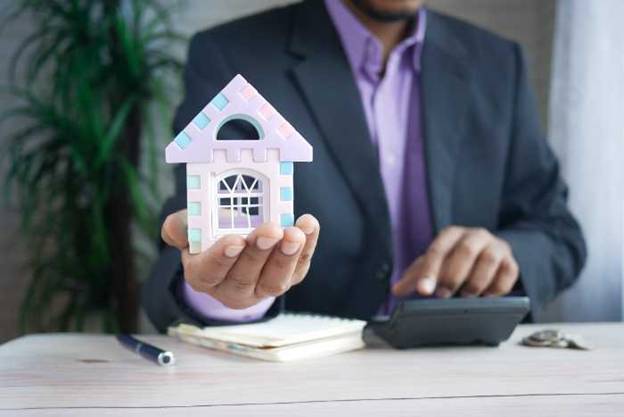 man holding a little house